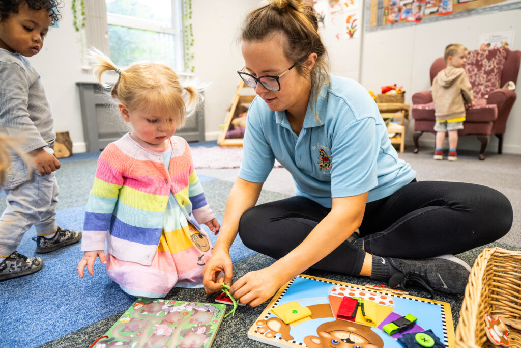 Child and nursery practitioner playing