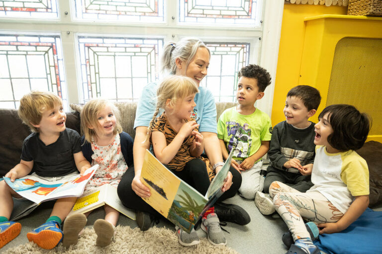 Nursery teacher and children reading